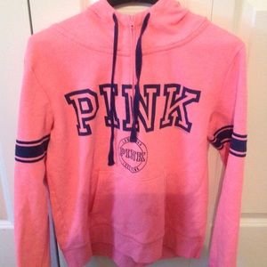 pink sweater with logo across the front in blue